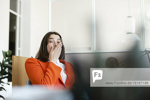 Tired businesswoman yawning in office