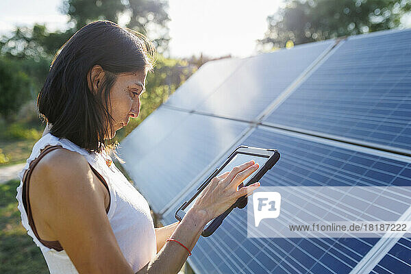 Reife Frau nutzt Tablet-PC durch Sonnenkollektoren