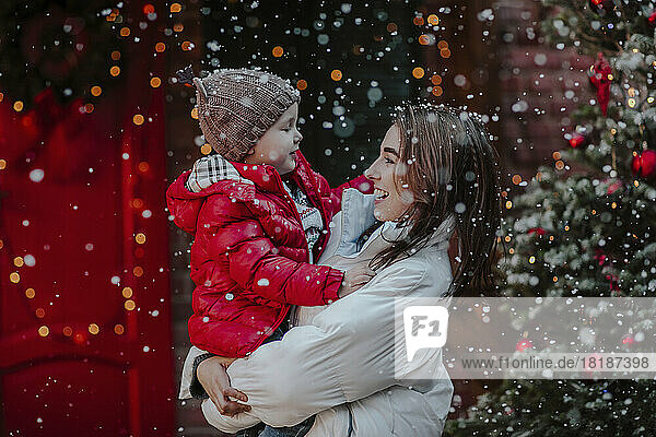 Cheerful mother with son enjoying in snow