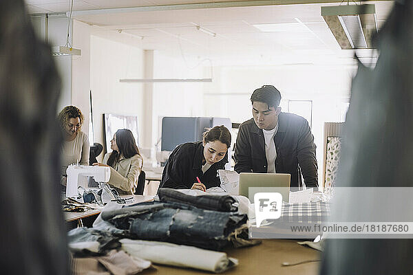 Multirassische männliche und weibliche Design-Experten arbeiten in einem Workshop an einem Laptop