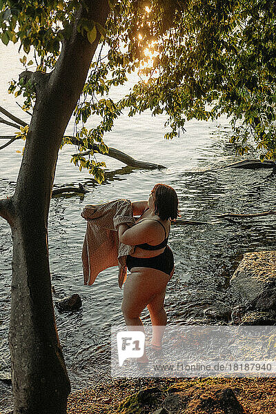 Hohe Winkel Ansicht der jungen Frau mit Handtuch stehen im Wasser durch Baum