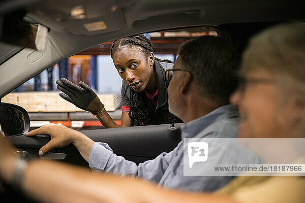 Verkaufspersonal führt Kunden im Auto sitzend durch einen Baumarkt