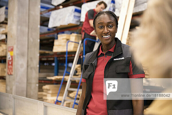 Lächelnde Verkäuferin im Gespräch mit einer Kundin im Baumarkt