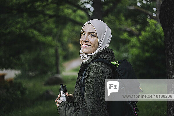 Portrait of smiling woman in hijab hiking on weekend
