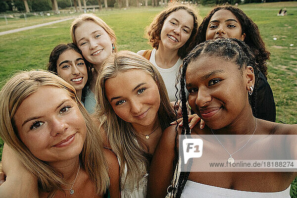 Lächelndes multirassisches Teenager-Mädchen macht ein Selfie im Park