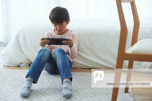 Japanese kid playing games at home