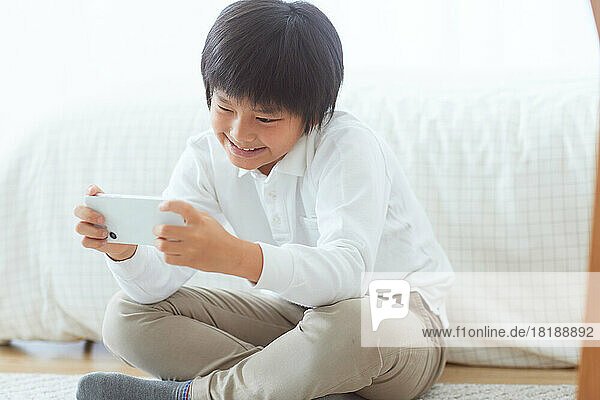Japanese kid using smartphone at home