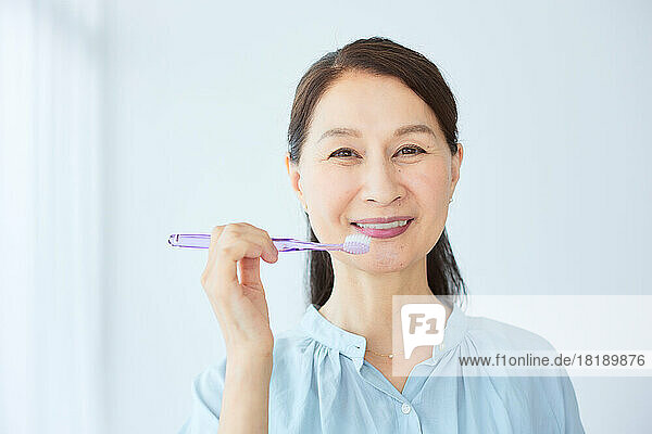 Japanese senior woman brushing teeth