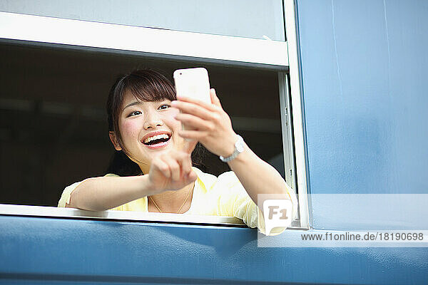Japanese woman taking pictures from train window