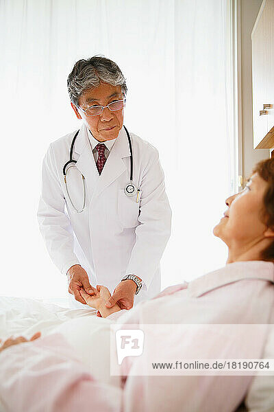 Japanese senior woman being examined by a doctor in a hospital room