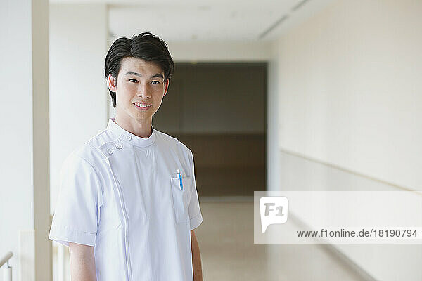 Smiling young male nurse in the hallway