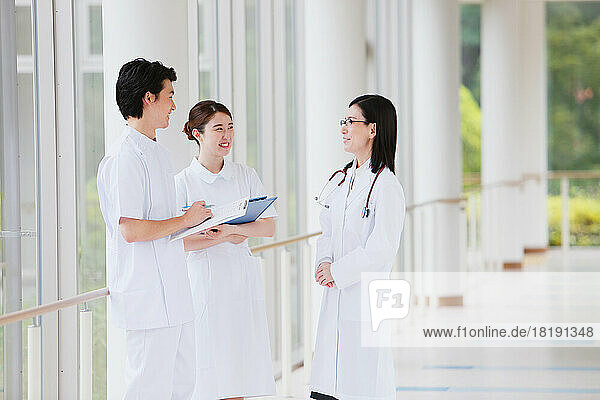 Two nurses and a doctor talking in the hallway