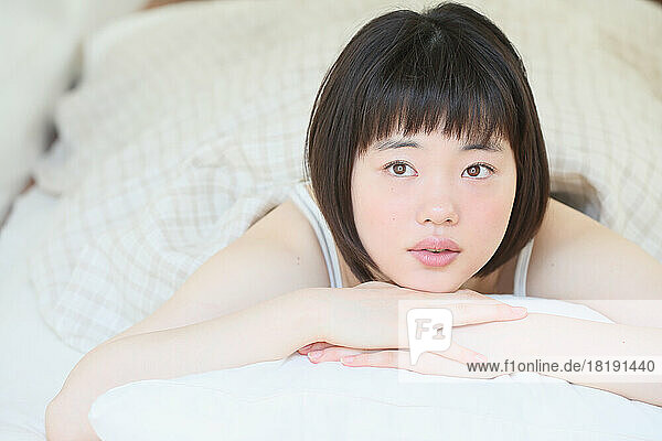 Young Japanese woman relaxing in bed