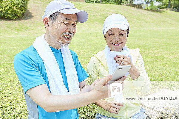 Japanese senior couple looking at mobile phone