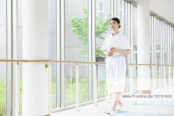 Young Japanese female nurse walking in the hallway