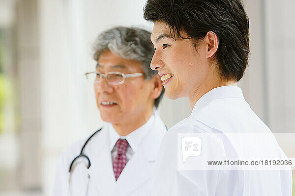 Japanese doctor and smiling young male nurse in the hallway