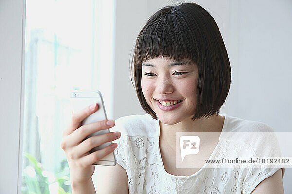 Young Japanese woman operating a mobile phone