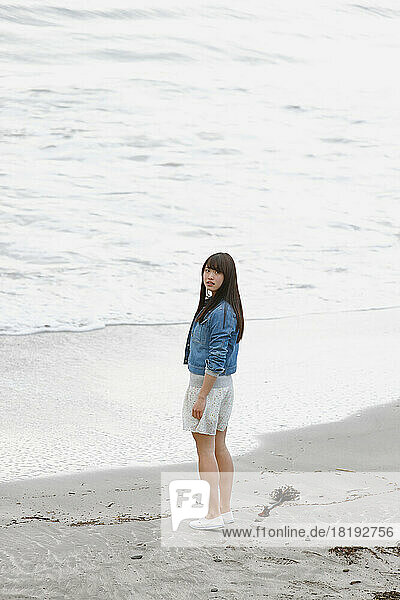 Young Japanese woman looking back on the beach