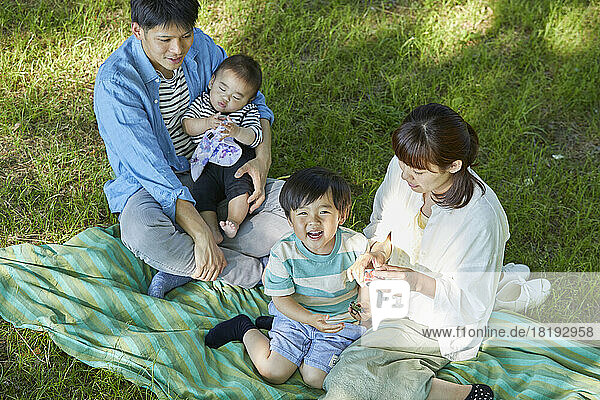 Japanese family relaxing on the lawn