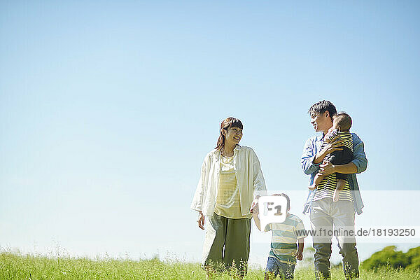 Blue sky and smiling Japanese family