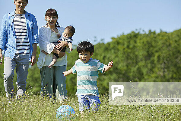Japanese parents watching over child playing ball