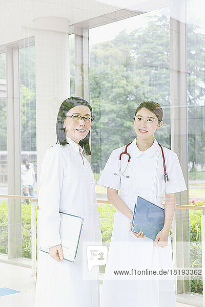 Smiling doctor and young female nurse in the hallway