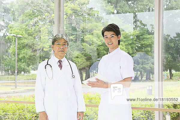Smiling Japanese doctor and young male nurse in the hallway