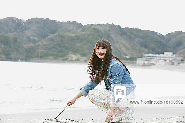 Japanese woman scribbling on the beach