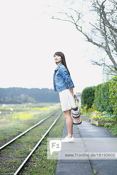 Young Japanese woman waiting for a train at the platform