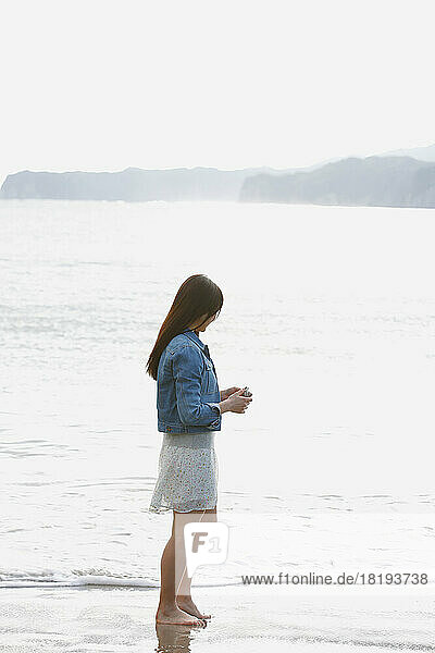 Japanese woman standing in front of the sea