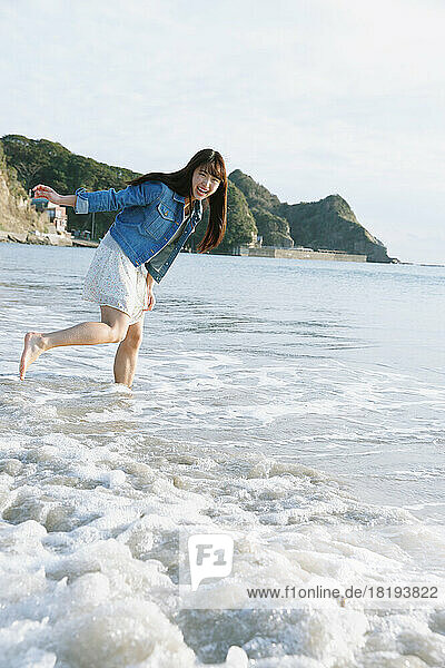 Young Japanese woman having fun on the beach