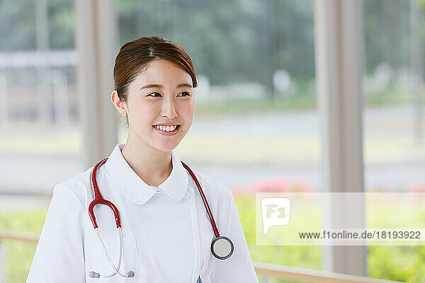 Smiling young Japanese female nurse in the hallway