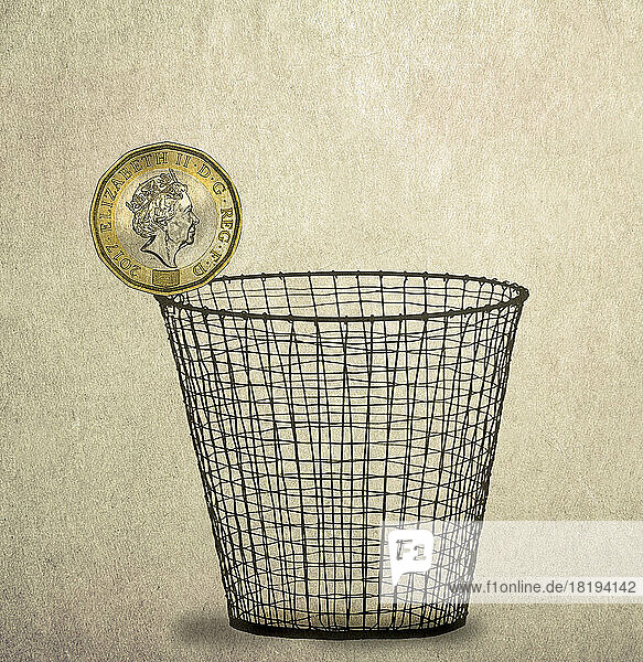 Ein-Pfund-Münze auf dem Rand eines Papierkorbs