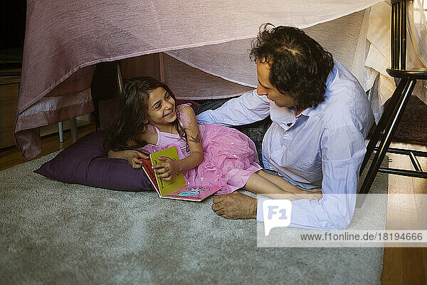 Man with his daughter in blanket fort