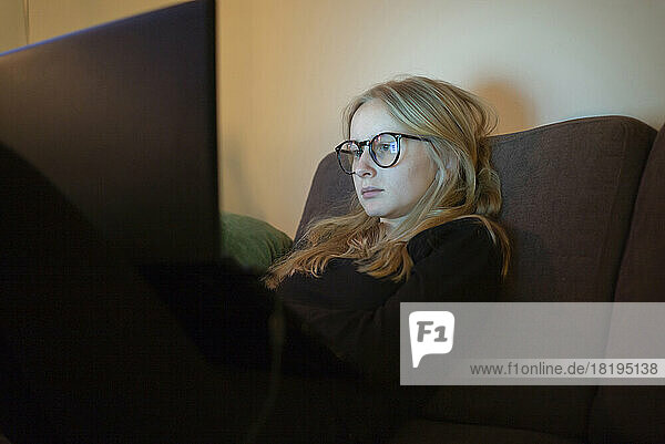 Teenage girl with glasses using laptop