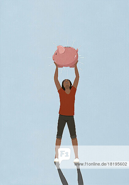 Happy woman holding shiny piggy bank overhead
