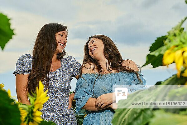 Zwei glückliche Frauen lachen auf einem Maisfeld