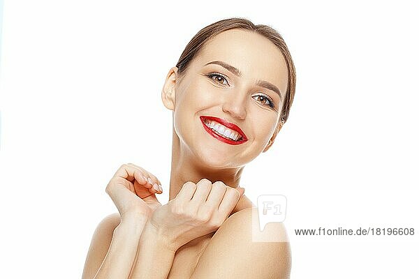 Glückliches schönes Mädchen mit den Händen am Kinn  das lachend zur Seite schaut. Zähne und Hautpflege