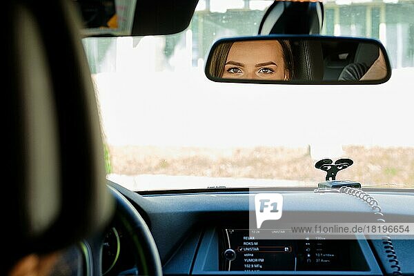 Reflection of female eyes in rearview mirror of a car
