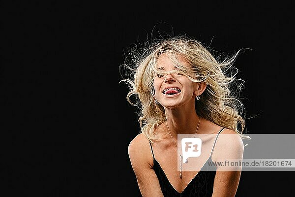 Unauffälliges Studiofoto einer jungen glücklichen Frau mit wallendem Haar