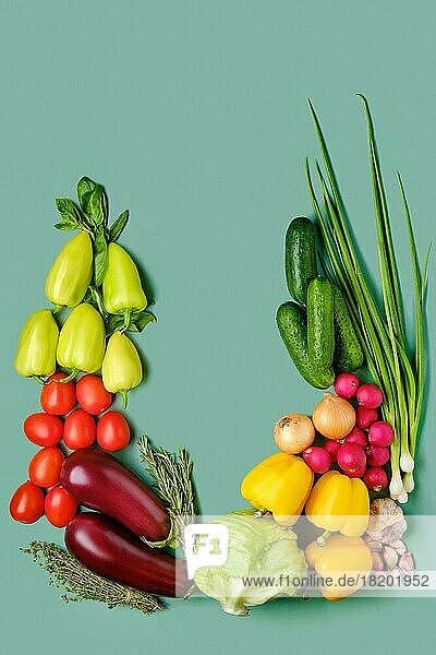 Komposition mit frischem Gemüse auf blassgrünem Hintergrund