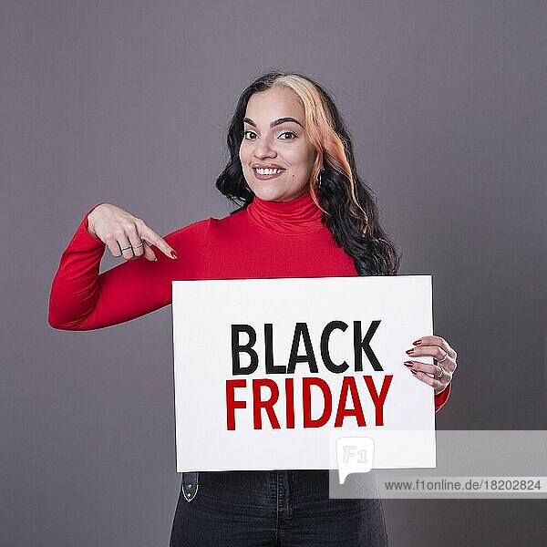 Schöne Frau  die auf ein Black Friday-Schild zeigt. Kommerzielles Konzept. Handel