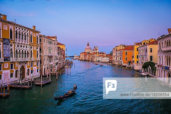 VENICE  ITALY  JULY 19  2019: View of Venice Grand Canal with boats gondola and boats and Santa Maria della Salute church in the day from Ponte dell'Accademia bridge on sunset. Venice  Italy  Europe