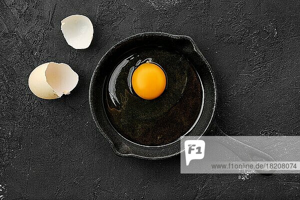 Rohes  ungekochtes Ei in einer kleinen gusseisernen Pfanne