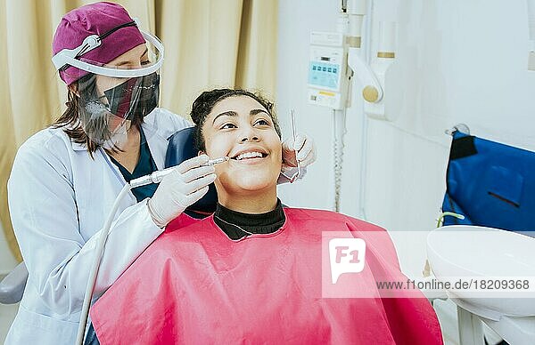 Eine Zahnärztin reinigt den Mund eines Patienten mit einem Bohrer. Nahaufnahme eines Stomatologen  der die Zähne einer Frau reinigt  Stomatologe reinigt Karies mit Bohrer  Stomatologe reinigt die Zähne eines Patienten