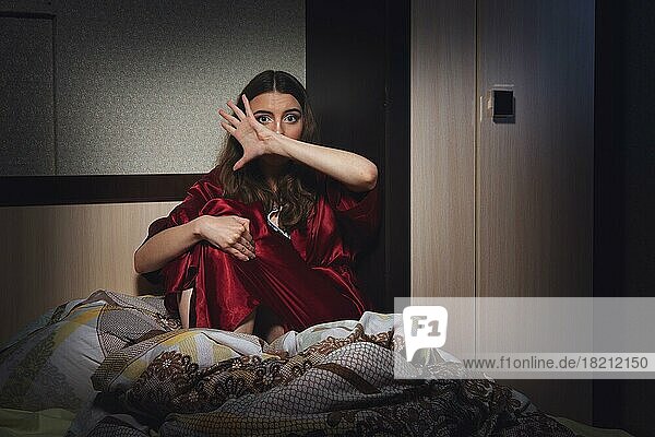Verängstigte verzweifelte Frau im Schlafzimmer. Soziale Gewalt