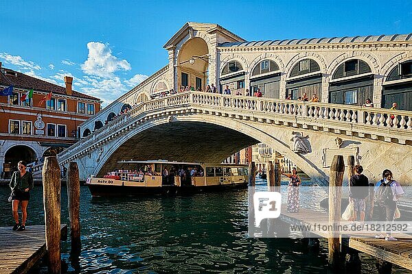 VENEDIG  ITALIEN  27. JUNI 2018: Rialtobrücke mit Vaporetto unter dem Canal Grande bei Sonnenuntergang  Venedig  Italien  Europa