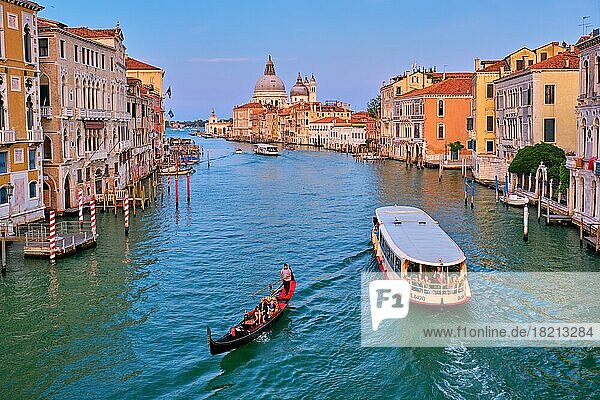 VENICE  ITALY  JULY 19  2019: View of Venice Grand Canal with boats gondola and vaporetto and Santa Maria della Salute church in the day from Ponte dell'Accademia bridge on sunset. Venice  Italy  Europe