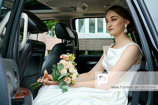 Schöne Braut sitzt auf der Rückbank eines Autos
