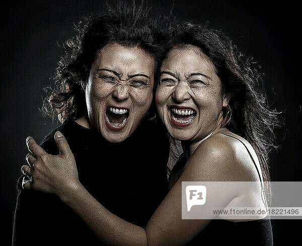 Two Asian woman  sisters  Korean siblings  embrace  scream
